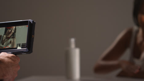 Filming-Skincare-Beauty-Video-Shot-Of-Young-Woman-With-Long-Braided-Hair-Putting-Moisturiser-Onto-Arms